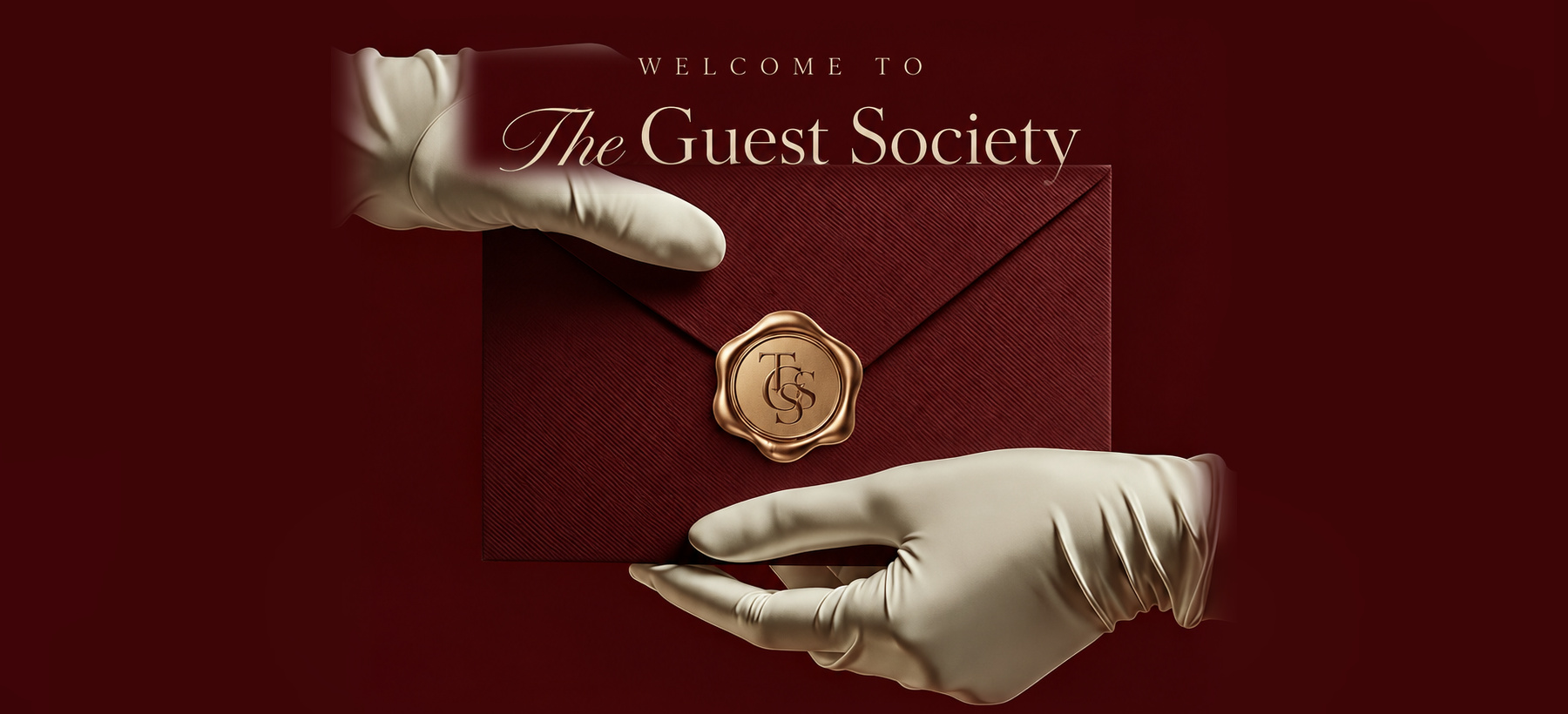 The Guest Society burgundy invitation held by white-gloved hands